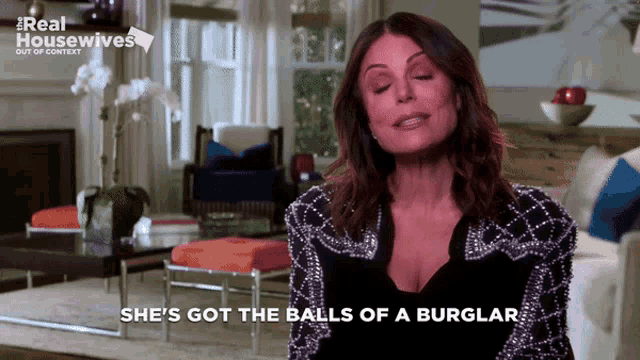 a woman says she 's got the balls of a burglar while standing in a living room