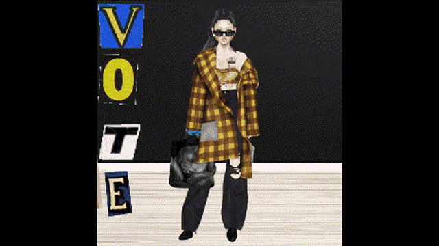 a woman in a plaid coat is standing in front of a wall that says vote