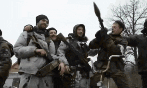 a group of soldiers are posing for a picture with one holding a rocket