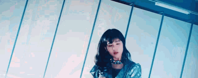 a woman in a futuristic outfit is dancing in front of a white wall