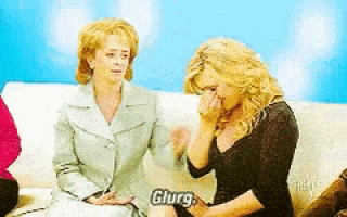 two women are sitting on a couch and one of them is crying and says glurg
