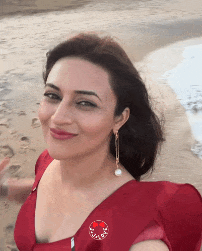 a woman wearing a red dress has a badge that says i love