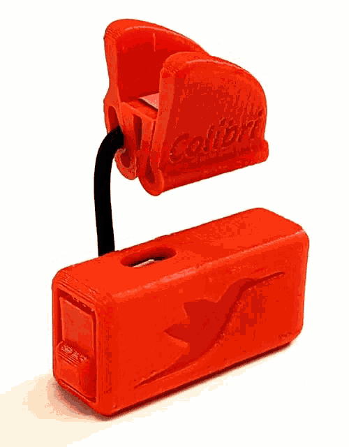 a red plastic object with a black handle on a white surface