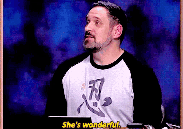 a man with a beard is wearing a shirt that says she 's wonderful .