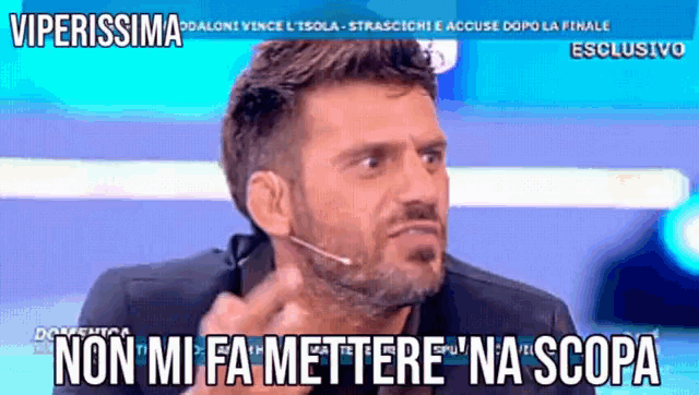 a man talking into a microphone with the words non mi fa mettere na scopa written below him