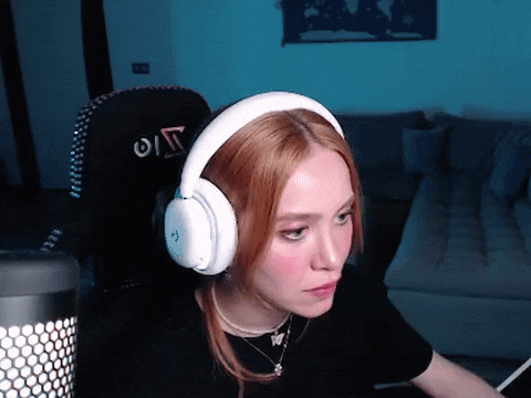 a woman wearing white headphones is sitting in a chair with the letter o on the back