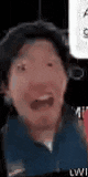 a man is making a funny face with his mouth open in a dark room .