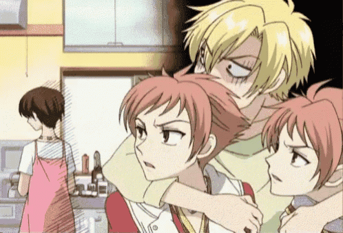 a couple of anime characters standing next to each other in a kitchen with a woman in the background .
