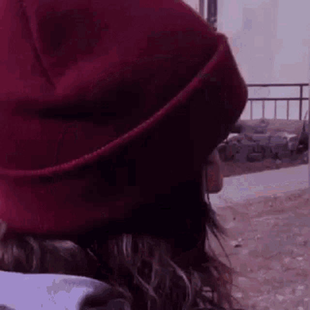 a close up of a person wearing a red beanie hat .
