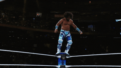 a man in a blue and white outfit is wrestling another man in a blue and white outfit
