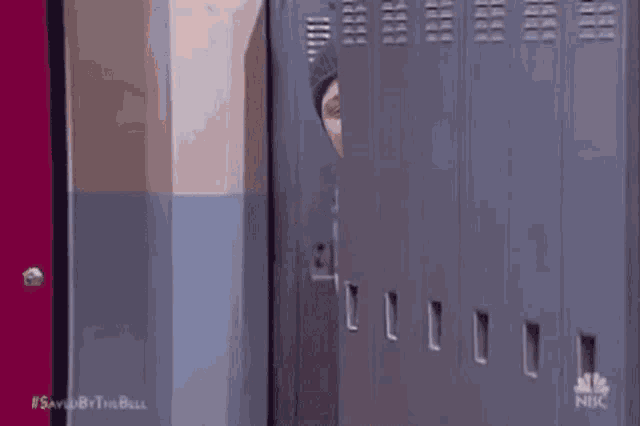 a man 's head is sticking out of a locker and the word trade is on the wall behind him .