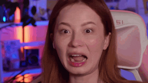 a woman is making a funny face while sitting in a gaming chair .