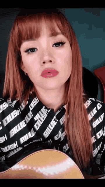 a girl with red hair is wearing a billie eilish shirt