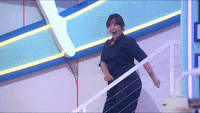 a woman is standing on a staircase with a white railing