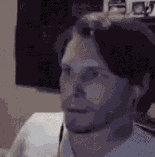 a man with a beard and a white shirt is making a funny face .