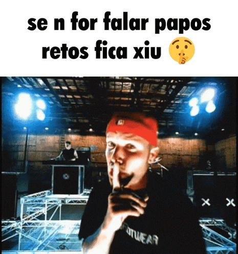 a man wearing a red headband holds his finger to his lips and says se n for falar papos