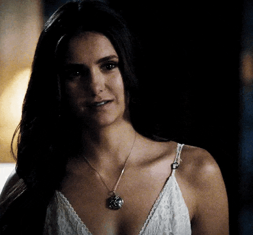 a woman wearing a white lace top and a necklace