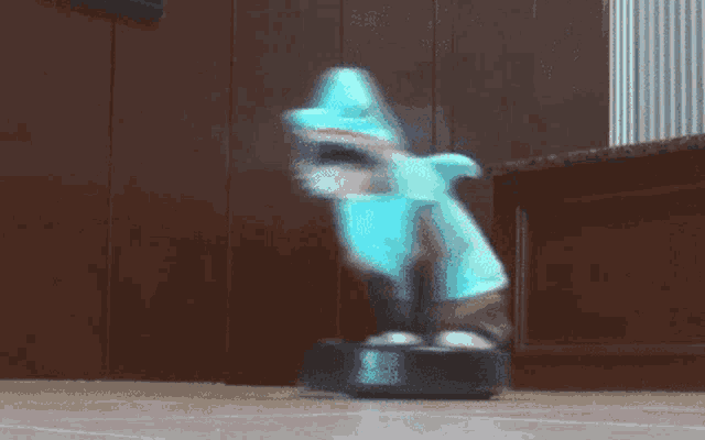 a blurry picture of a person in a shark costume riding a robotic vacuum cleaner .