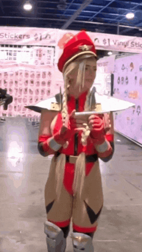 a woman in a cammy costume is standing in front of a sign that says stickers $ 1