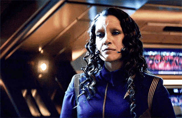 a woman in a purple jacket with a headset on her ear