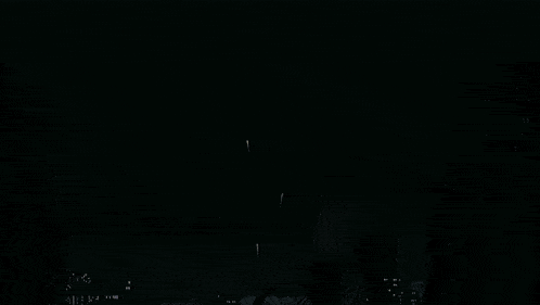 a man and a woman watching fireworks in the dark
