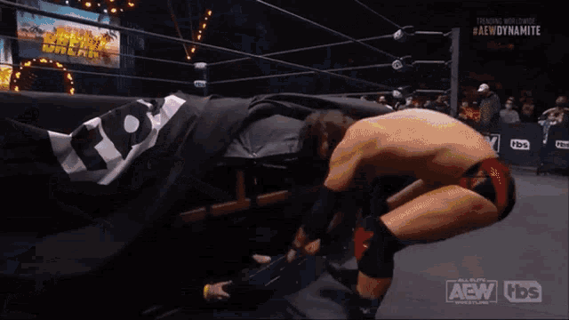 a wrestler with a mask on his face is standing in a wrestling ring .