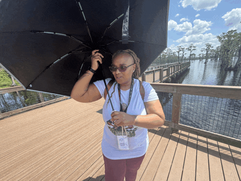 a woman holding an umbrella while wearing a lanyard with a name tag that says ' amanda ' on it