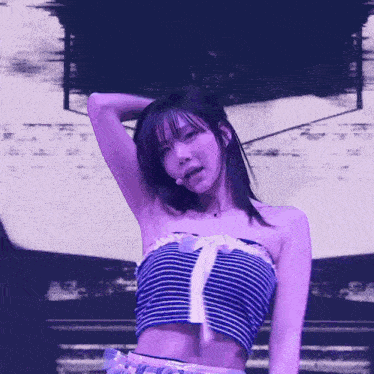 a woman in a striped top is standing in front of a purple screen