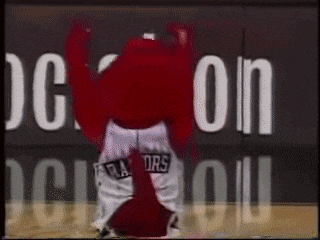 a mascot is dancing on a basketball court in front of a nba sign
