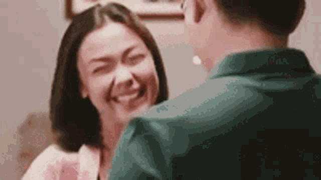 a man and a woman are laughing at each other .
