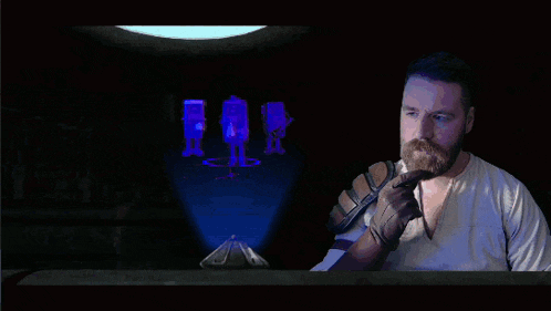a man with a beard is pointing at a screen with a purple background