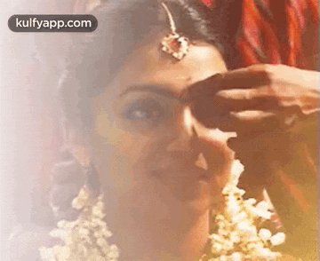 a close up of a woman 's face with a man 's hand on it .