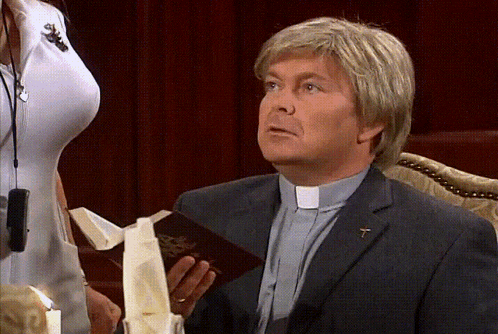 a man in a suit holds a bible with a cross on his lapel