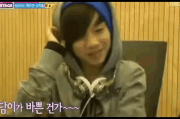 a young boy wearing headphones and a hooded jacket with korean writing