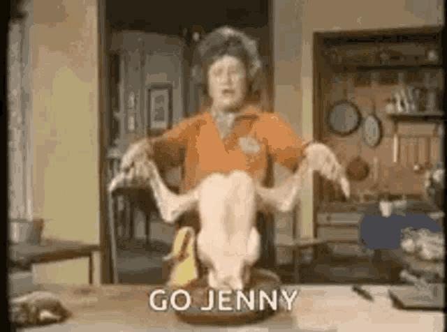 a woman is holding a dead turkey on a table .