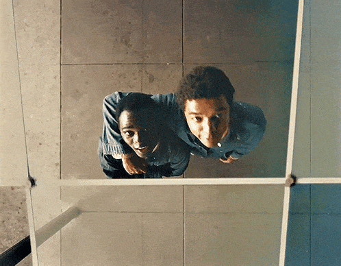 a couple of men are looking up at something