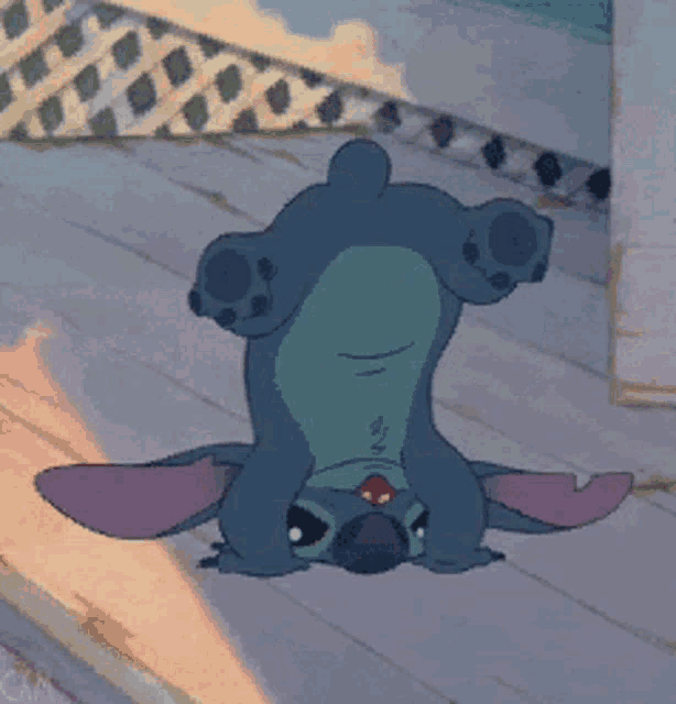 a cartoon character is laying upside down on a wooden floor
