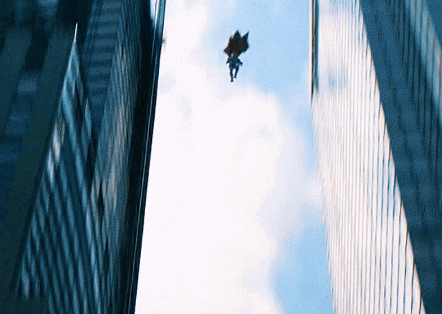 a person flying through the air between two buildings
