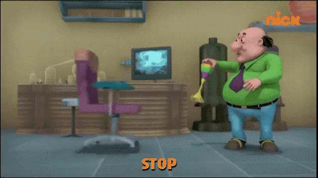 a man in a green shirt and tie is standing in front of a pink chair and a computer with the word stop written in orange
