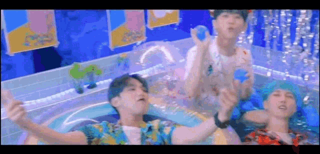 a group of young men are playing in a pool .