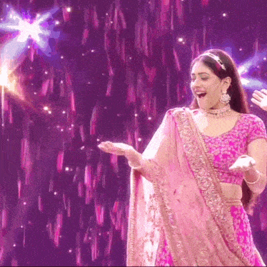 a woman in a pink and gold dress is dancing