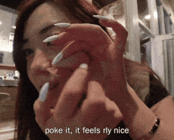 a woman with long white nails has the words poke it it feels rly nice above her