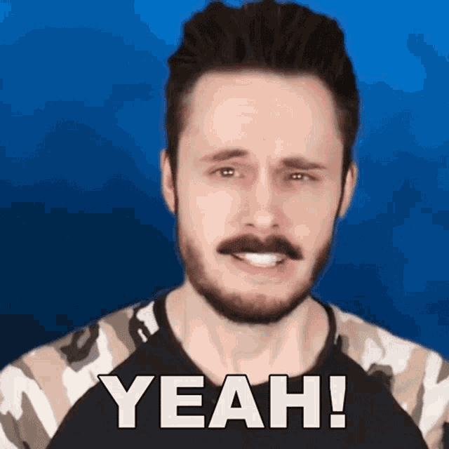 a man with a beard and mustache is wearing a camouflage shirt and saying yeah