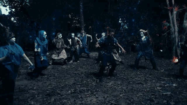 a man is standing in front of a group of zombies .