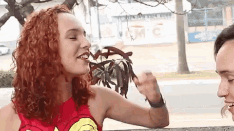 a woman with red hair is wearing a wonder woman costume .