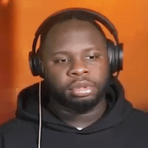 a man with a beard wearing headphones and a black hoodie .