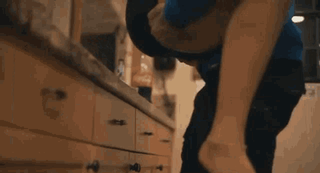 a man in a blue hoodie is carrying a woman in his arms .