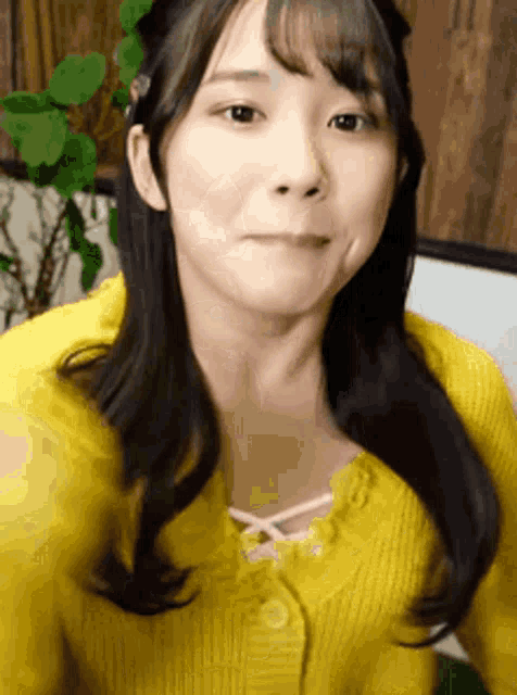 a woman in a yellow sweater is making a funny face