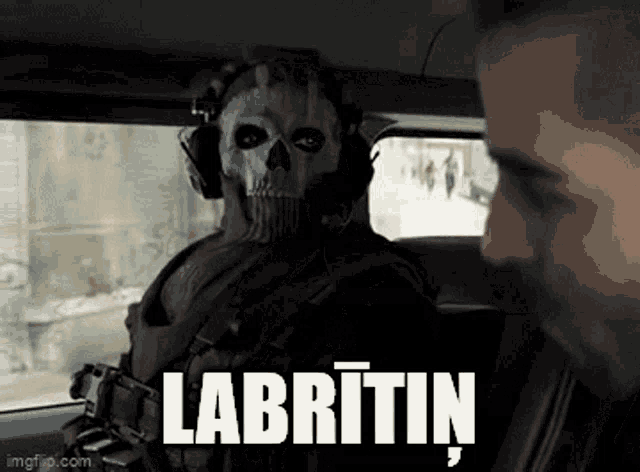 a man wearing a skull mask and headphones is sitting in a car next to another man .