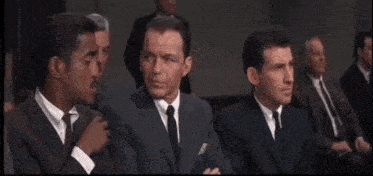 a group of men in suits and ties sitting in a room